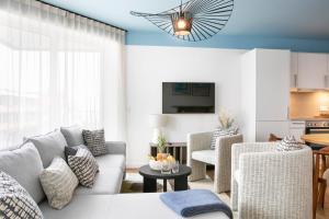Seehuus Duhnen Apartments في كوكسهافن: غرفة معيشة مع أريكة وكراسي وطاولة
