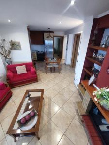 a living room with a red couch and a table at Venia's House in Ammouliani