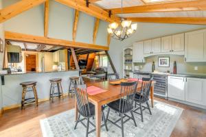 una cucina e una sala da pranzo con tavolo e sedie in legno di Inviting A-Frame Cabin with Saltwater Hot Tub! a Warren