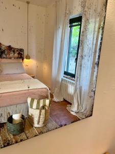 Casetta Valmora في Valpiana: مرآة تعكس غرفة نوم مع سرير ونافذة