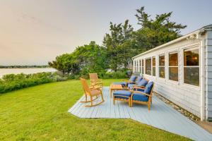 un gruppo di sedie e un tavolo su una terrazza di Waterfront Cottage with Sunroom and Patio and Grill a Clinton