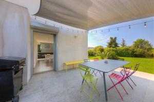 uma cozinha e sala de jantar com mesa e cadeiras em Villa Contemporaine à Carros les plans em Carros