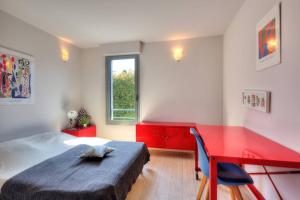 um quarto com uma cama e uma secretária vermelha em Villa Contemporaine à Carros les plans em Carros