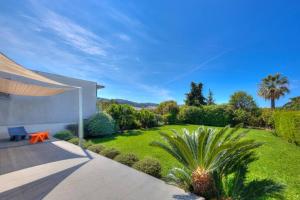 a garden with a lawn and a house at Villa Contemporaine à Carros les plans in Carros