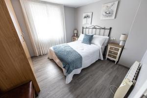 a small bedroom with a bed and a window at Casa Barreiro in Camariñas