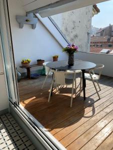 uma mesa e cadeiras numa varanda com uma janela em Loft en duplex avec terrasse Halles em Biarritz