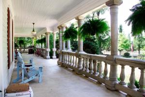 a porch with columns and a blue bench on a house at Belton Bed and Breakfast in Belton