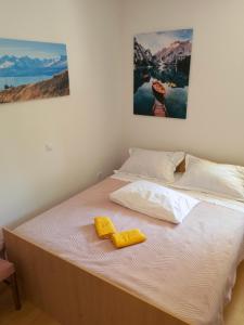 een wit bed met twee gele handdoeken erop bij Apartmani Stipe Buljević 2 in Lokva Rogoznica
