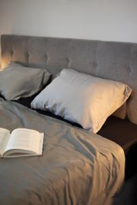 ポレッチにあるVitamin Seaの枕付きのベッドの上に座るオープンブック