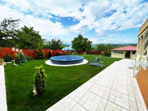 a backyard with a pool and an umbrella at Hotel Legiandro Surami in Surami