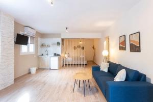 een woonkamer met een blauwe bank en een tafel bij Olivia Apartments in Pefkochori