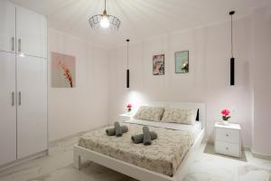 1 dormitorio blanco con 1 cama grande y paredes blancas en Nina's Luxury Apartments, en Corfú