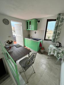 une cuisine avec des armoires vertes, une table et des chaises dans l'établissement Mille Lire, à Palerme