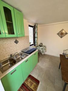 a kitchen with green cabinets and a sink at Mille Lire in Palermo
