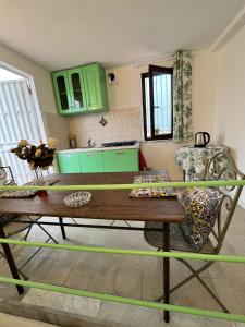 kuchnia z zielonymi szafkami i drewnianym stołem w obiekcie Mille Lire w mieście Palermo
