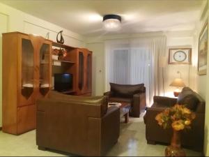 亞松森的住宿－EDIFICIO ASUNCIÓN，客厅配有皮革家具和电视