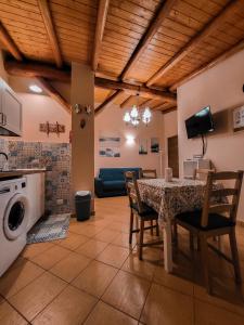 eine Küche und ein Esszimmer mit einem Tisch und Stühlen in der Unterkunft Il Gelsomineto dell'Etna in Nicolosi