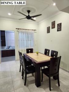 a dining table with chairs and a ceiling fan at Galaxy Guest Home by Ipoh Maju Stay in Ipoh