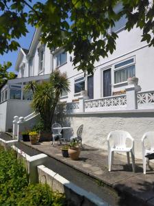 a group of chairs sitting in front of a building at Barclay Court Guest House in Torquay