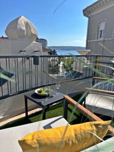 balcón con mesa y vistas al océano en Villa Olivetta heritage residence, en Crikvenica