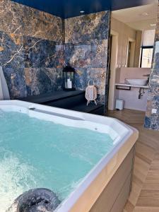 El baño incluye bañera con agua azul. en Villa Olivetta heritage residence, en Crikvenica