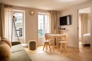 a living room with a couch and a table at Résidence Nell Paris in Paris