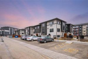 a parking lot with cars parked in front of buildings at Quiet, modern, stylish, one King & two Queen size beds, central location, parking in Winnipeg