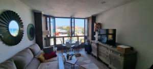 un soggiorno con divano e una grande finestra di Apartamento la Escalerona con vistas al mar a Gijón