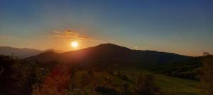 a sunset over a mountain range with the sun in the sky at Sunset House Sarajevo in Sarajevo