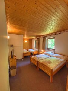 a bedroom with a large bed in a wooden ceiling at Penzion Peklo in Jeseník