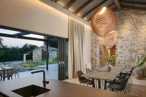 cocina y comedor con pared de piedra en Stone House Baracchi, en Lanišće