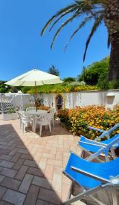 a patio with a table and chairs and an umbrella at il colibri' in Procida