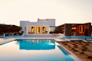 a swimming pool in front of a house at Amalthea, Outstanding Seaside Luxury Villa, Paros in Santa Marina