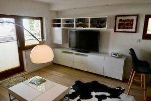 ein Wohnzimmer mit einem TV und einem Tisch in der Unterkunft 42up Berlin Pankow in Berlin