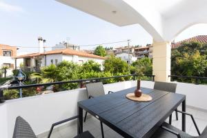 een zwarte tafel op een balkon met stoelen bij Olivia Apartments in Pefkochori