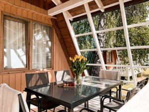 a glass table and chairs on a porch at Kaper Łeba - Domki Nad Morzem in Łeba