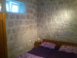 a bedroom with two beds and a brick wall at Apartments Eldi in Split
