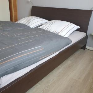 una cama con almohadas blancas encima en Das Düsselapartment, en Haan