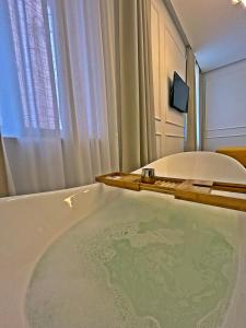 bañera en una habitación con ventana en Villa Olivetta heritage residence, en Crikvenica