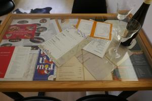 - une table avec des papiers et une bouteille de vin dans l'établissement 42up Berlin Pankow, à Berlin