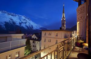 una vista da un balcone di un edificio con torre dell'orologio. di Top of the World Apartment a Sankt Moritz