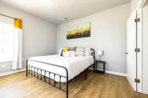- une chambre avec un lit aux murs blancs et du parquet dans l'établissement The Hive - Downtown Stephenville, à Stephenville