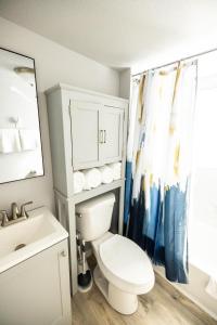 La salle de bains est pourvue de toilettes blanches et d'un lavabo. dans l'établissement The Hive - Downtown Stephenville, à Stephenville