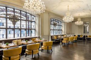 a dining room with tables and chairs and chandeliers at Magnolia Hotel St. Louis, a Tribute Portfolio Hotel in Saint Louis +68 photos