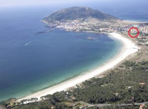 z góry widok na plażę z czerwonym krągiem w obiekcie Apartamento Capricho Finisterre Playa w mieście Fisterra