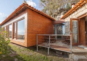 a wooden house with a large window and a deck at Casa Do Fragao in Bouro