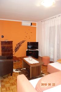 uma sala de estar com paredes cor de laranja e uma mesa em Apartman Stella em Fasana