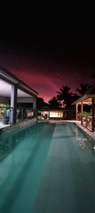 una gran piscina por la noche con areens en VILLA SUNRISE MOOREA en Papetoai