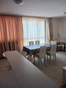 a dining room with a blue table and chairs at Byala Palace Apartments in Byala
