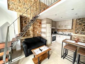 un soggiorno con divano nero e una scala di Lovinna Luxury Appartments a Calimno (Kalymnos)